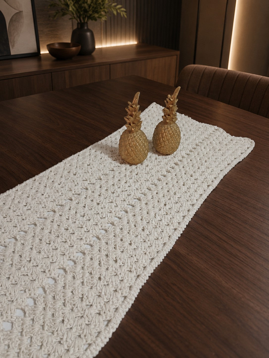 Ovela off-white textured crochet cotton table runner with two gold pineapple accents.