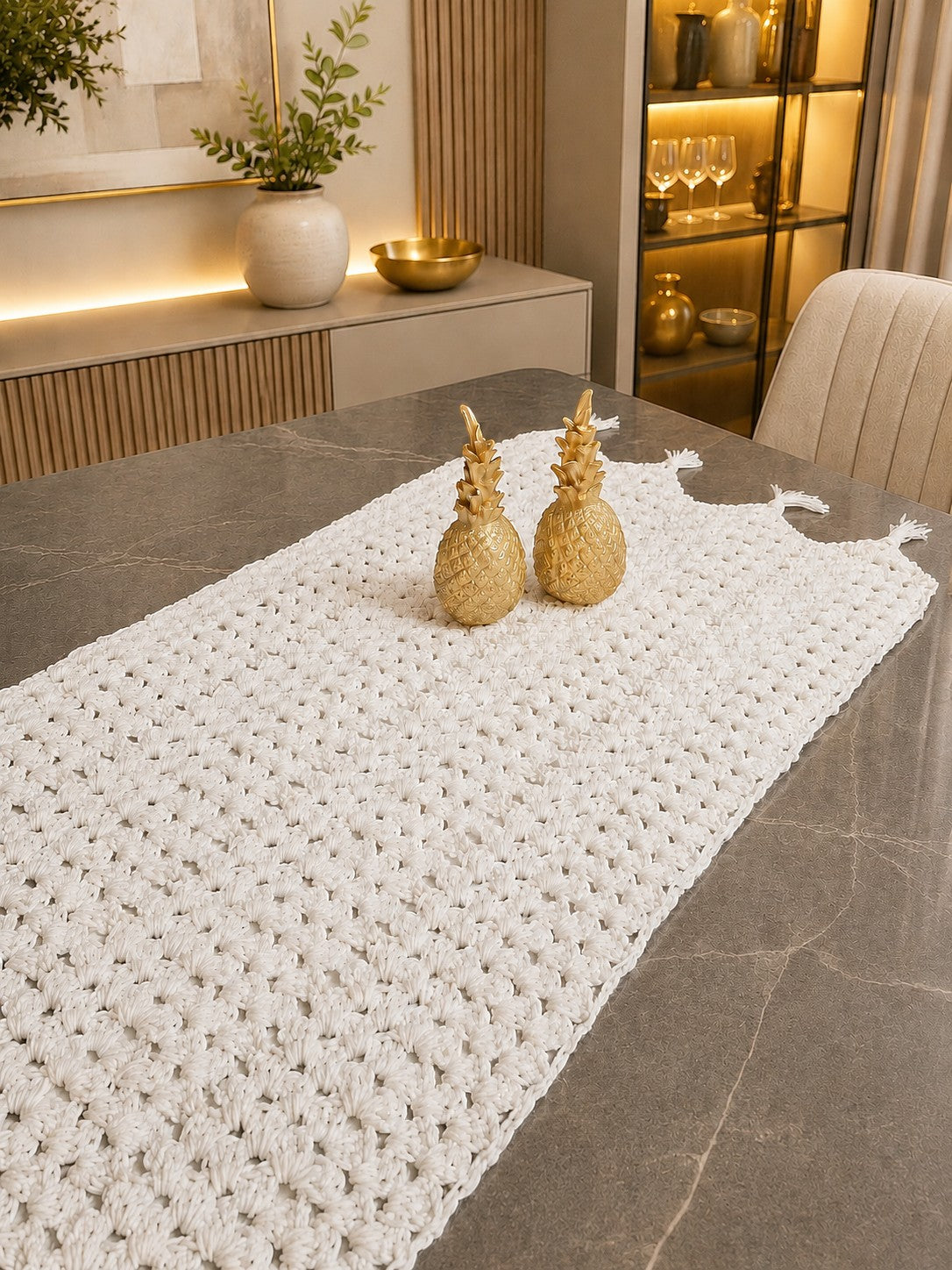Ovela white textured crochet cotton table runner with two gold pineapple accents, perfect for dining tables.